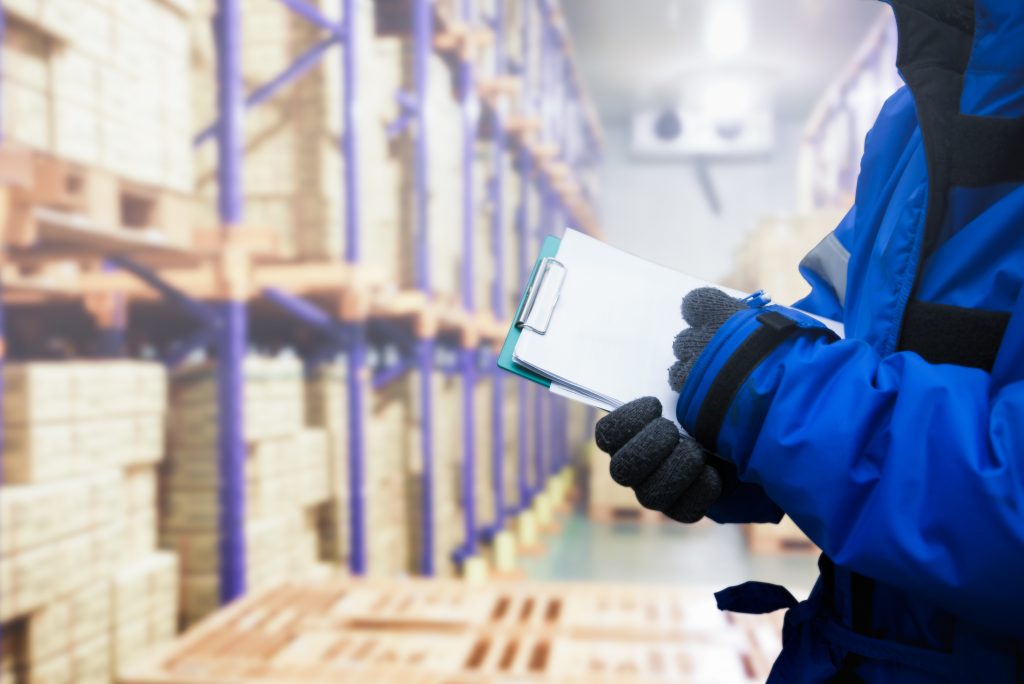 Closeup shooting hand of QC. worker checking goods on delivery in the cold room warehouse., Logistics food and beverage in cold storage concept Closeup shooting hand of QC. worker checking goods on delivery in the cold room warehouse., Logistics food and beverage in cold storage concept